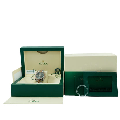 Rolex watch in an open green box with a closed box next to it on a white background