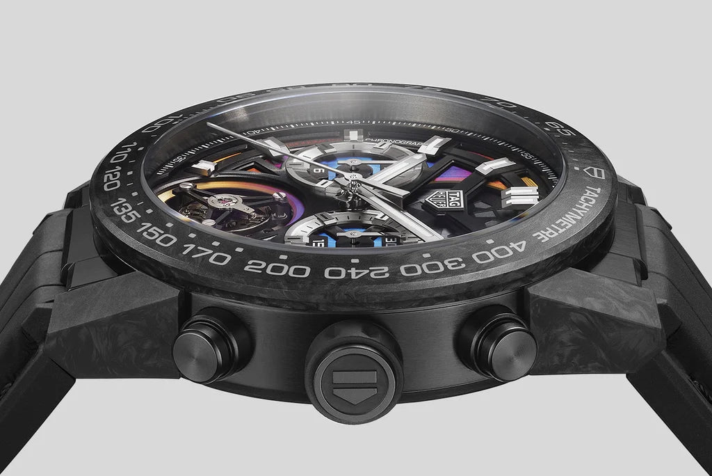 Close-up of a black watch with detailed face and brand logo on a light gray background