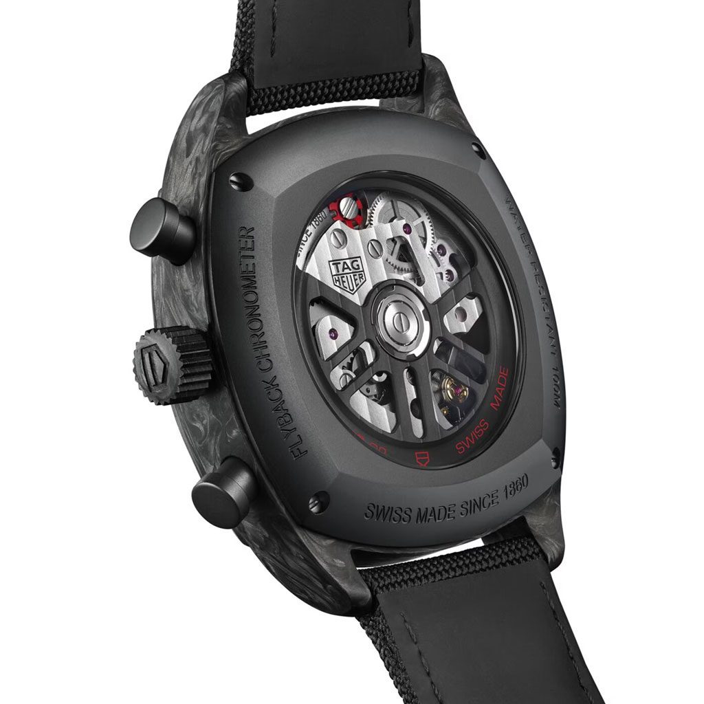 Close-up of a TAG Heuer watch with visible mechanical components on a white background