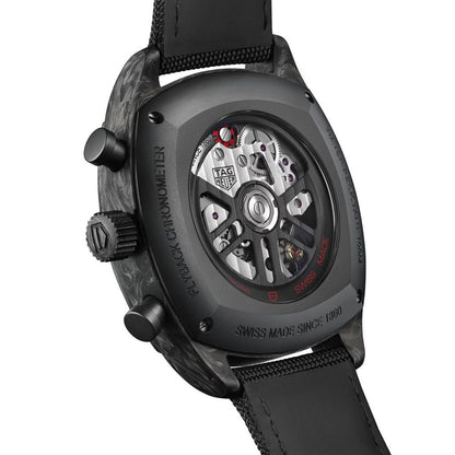 Close-up of a TAG Heuer watch with visible mechanical components on a white background