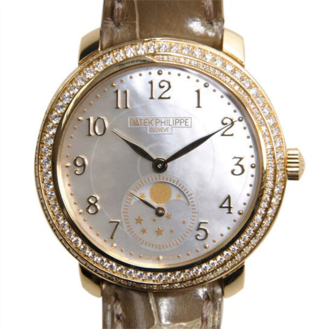 Gold wristwatch with diamond bezel on a white background